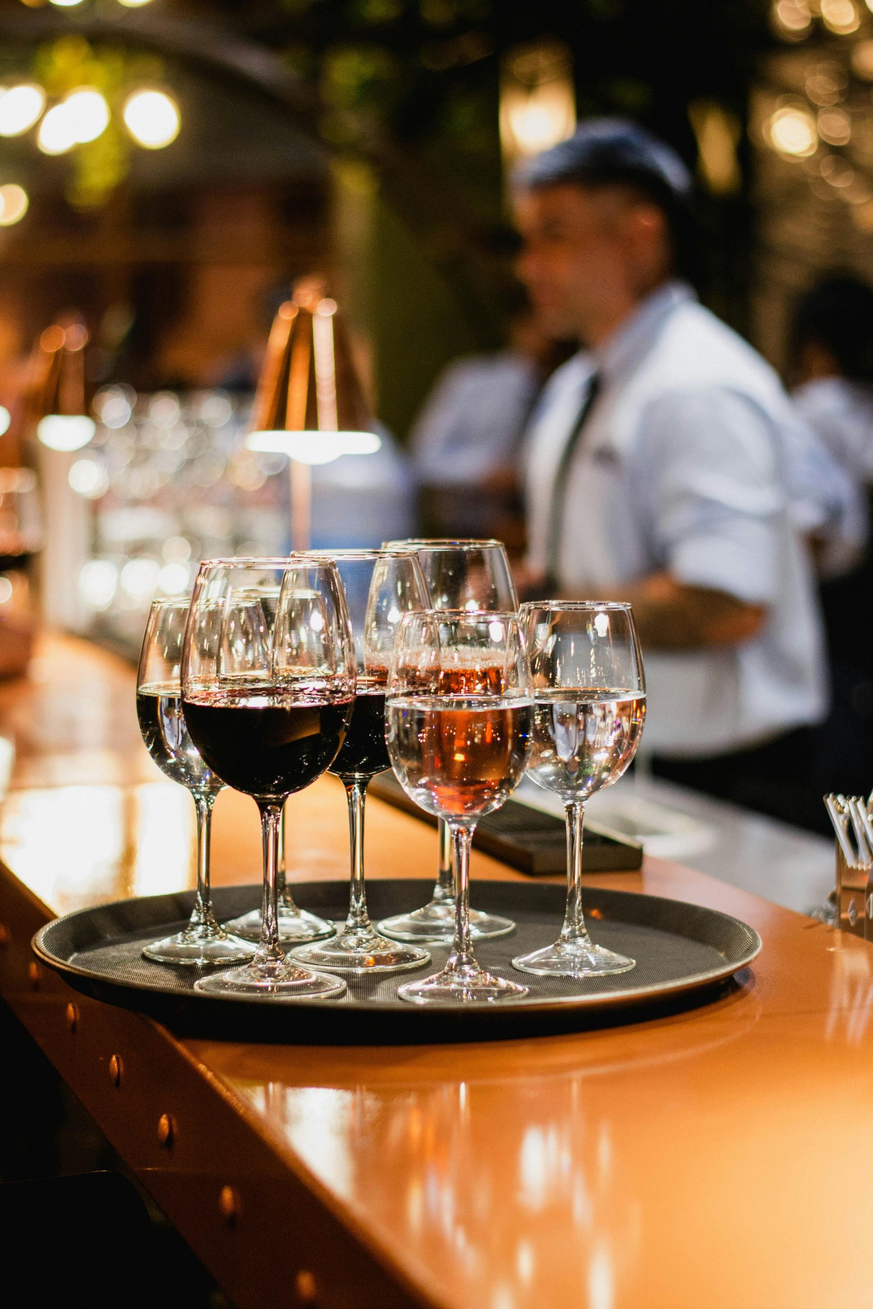 A selection of wine glasses on a bar counter in a cozy indoor setting.